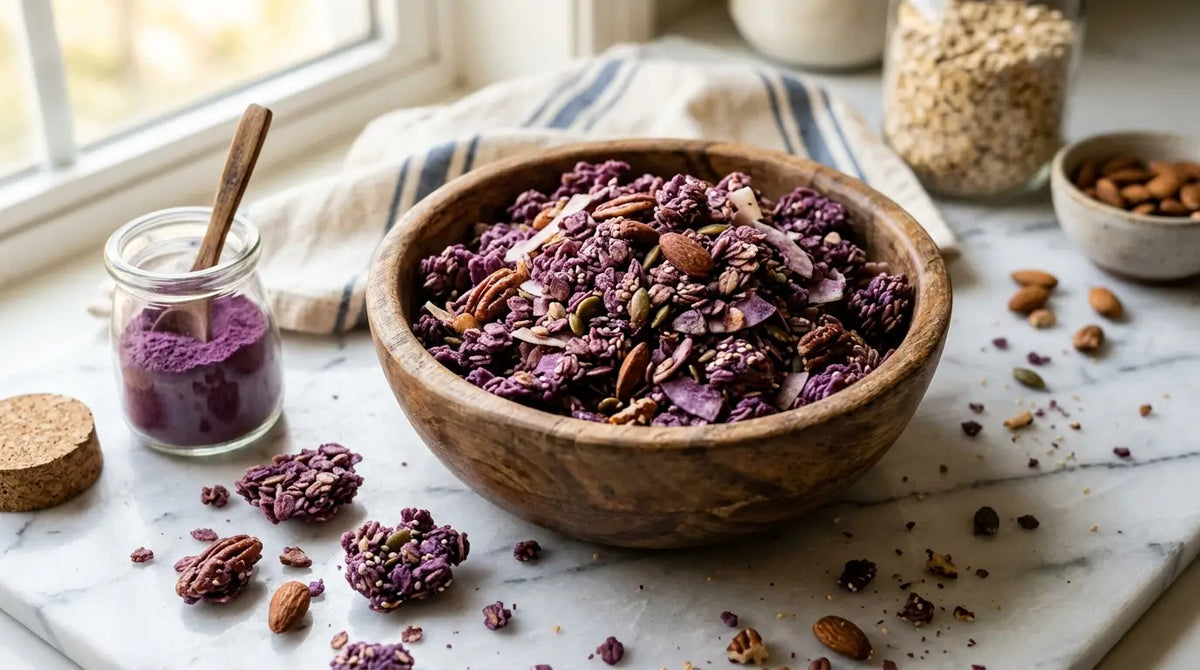 Bol de granola violet à l'ube avec amandes, noix et flocons de coco, bocal de poudre violette à côté