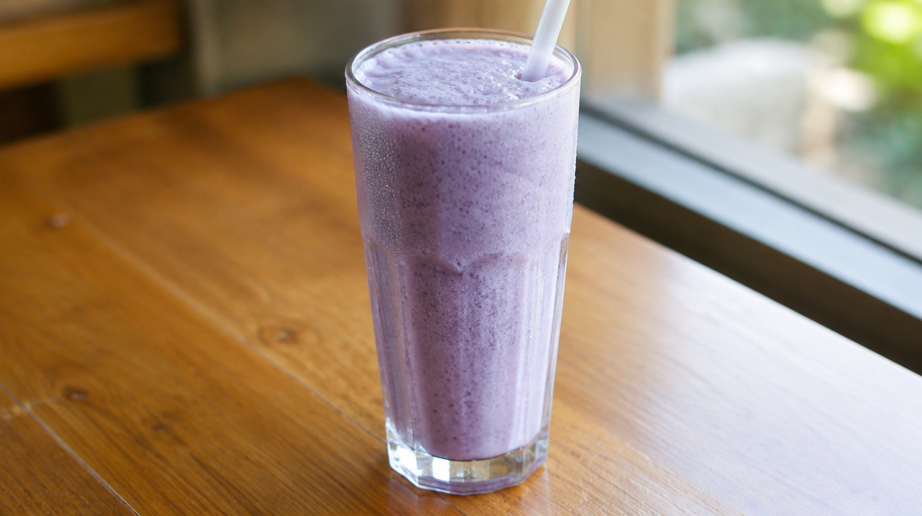 Frappé à l'ube violet dans un grand verre, texture glacée et mousseuse